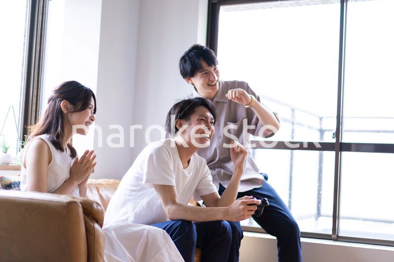 家でテレビゲームをする若い男女