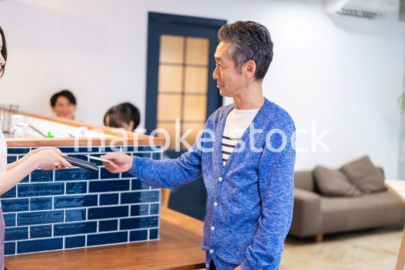 飲食店で電子マネー決済をする男性