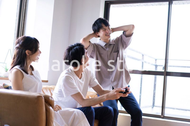 家でテレビゲームをする若い男女