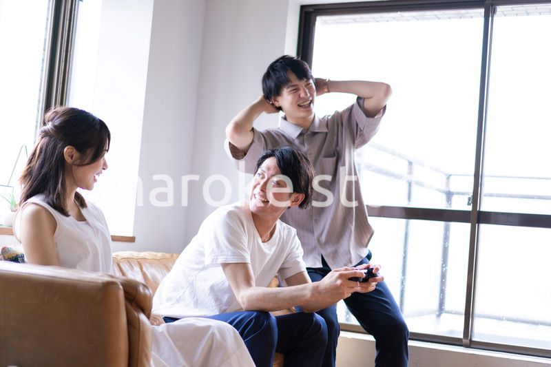 家でテレビゲームをする若い男女