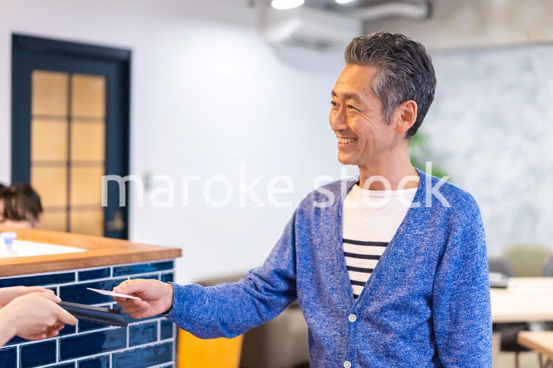 飲食店で電子マネー決済をする男性