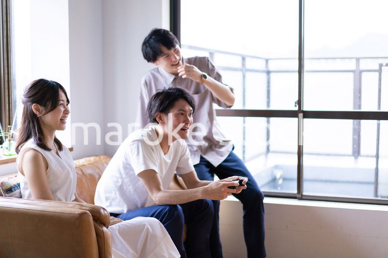家でテレビゲームをする若い男女