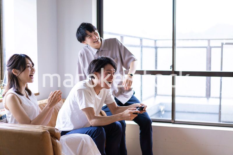 家でテレビゲームをする若い男女