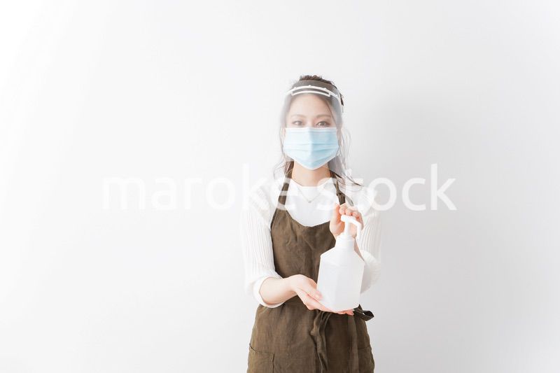 アルコール消毒液を差し出すカフェスタッフ