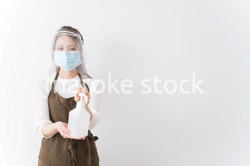アルコール消毒液を差し出すカフェスタッフ