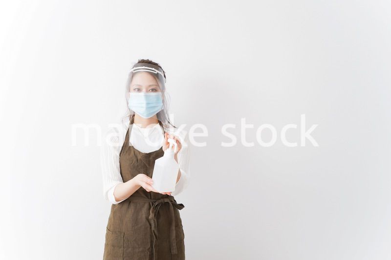 アルコール消毒液を差し出すカフェスタッフ