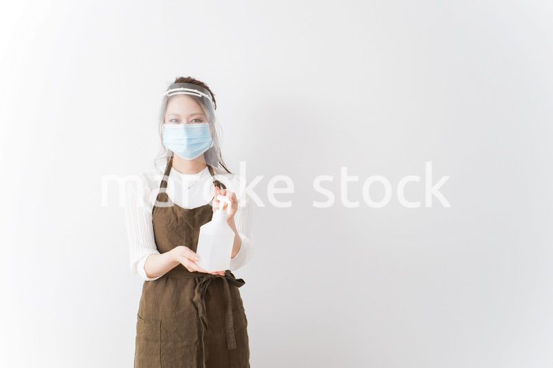 アルコール消毒液を差し出すカフェスタッフ