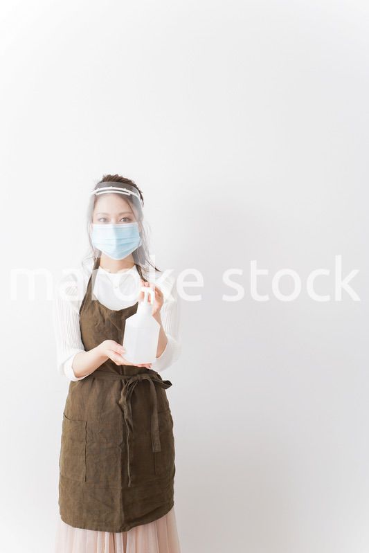 アルコール消毒液を差し出すカフェスタッフ