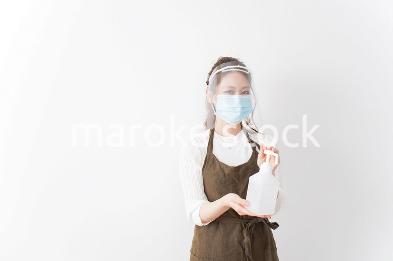 アルコール消毒液を差し出すカフェスタッフ