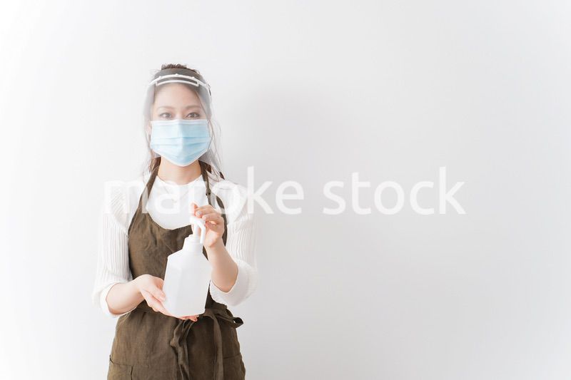 アルコール消毒液を差し出すカフェスタッフ