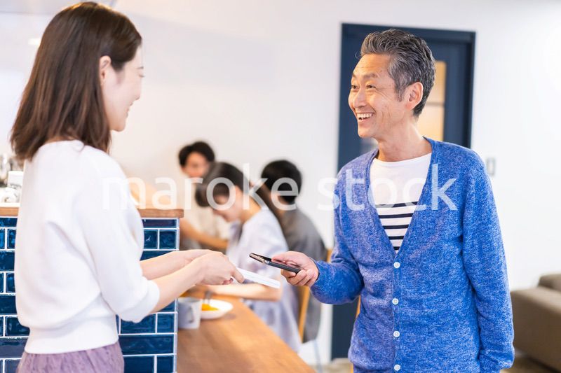 飲食店で電子マネー決済をする男性