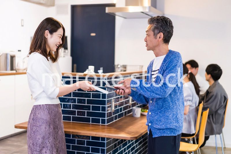 飲食店で電子マネー決済をする男性