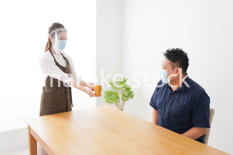 コロナウイルスの予防を徹底するカフェスタッフ