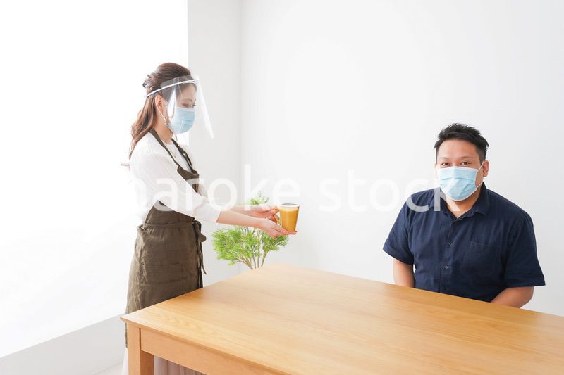 コロナウイルスの予防を徹底するカフェスタッフ