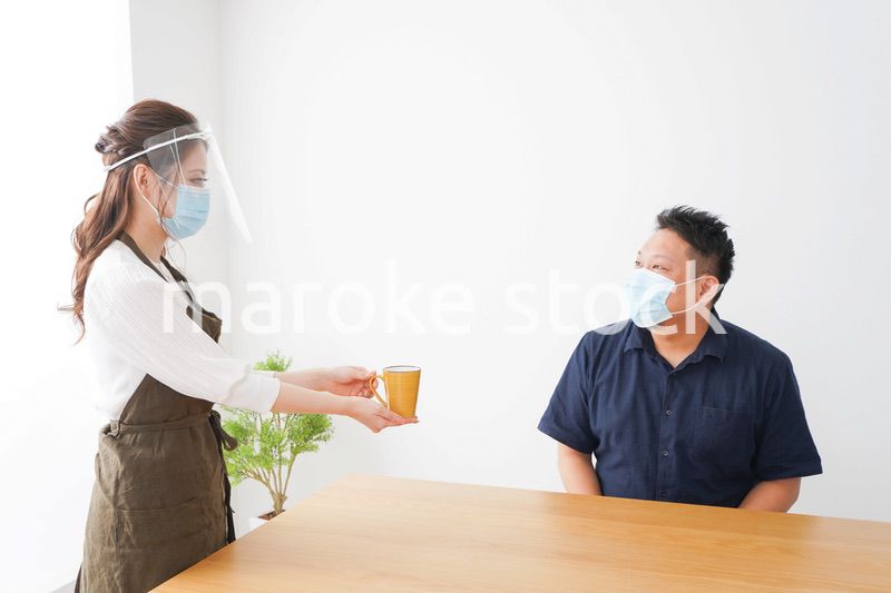 コロナウイルスの予防を徹底するカフェスタッフ