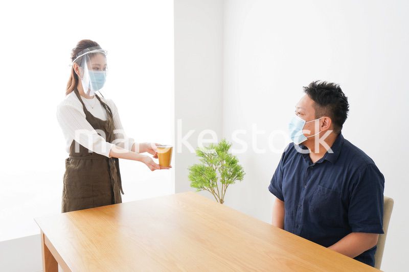 コロナウイルスの予防を徹底するカフェスタッフ