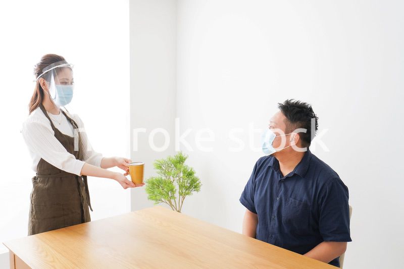 コロナウイルスの予防を徹底するカフェスタッフ