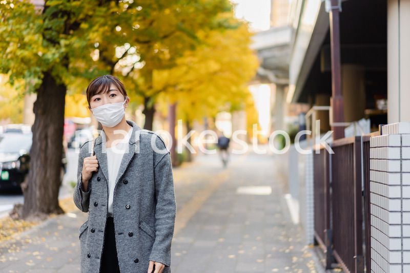 マスクをして街を歩く若い女性