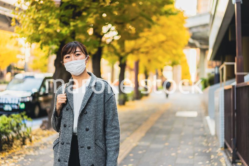 マスクをして街を歩く若い女性
