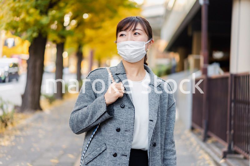 マスクをして街を歩く若い女性