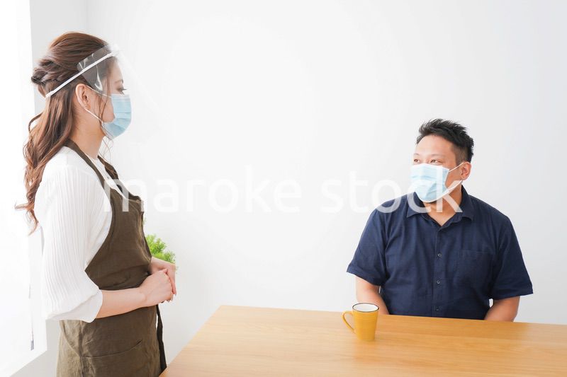 コロナウイルスの予防を徹底するカフェスタッフ