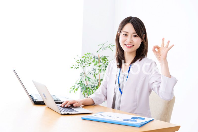 オフィスでグッドサインをする若いビジネスウーマン