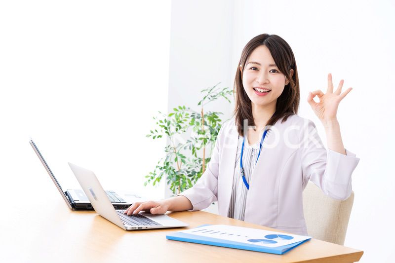 オフィスでグッドサインをする若いビジネスウーマン