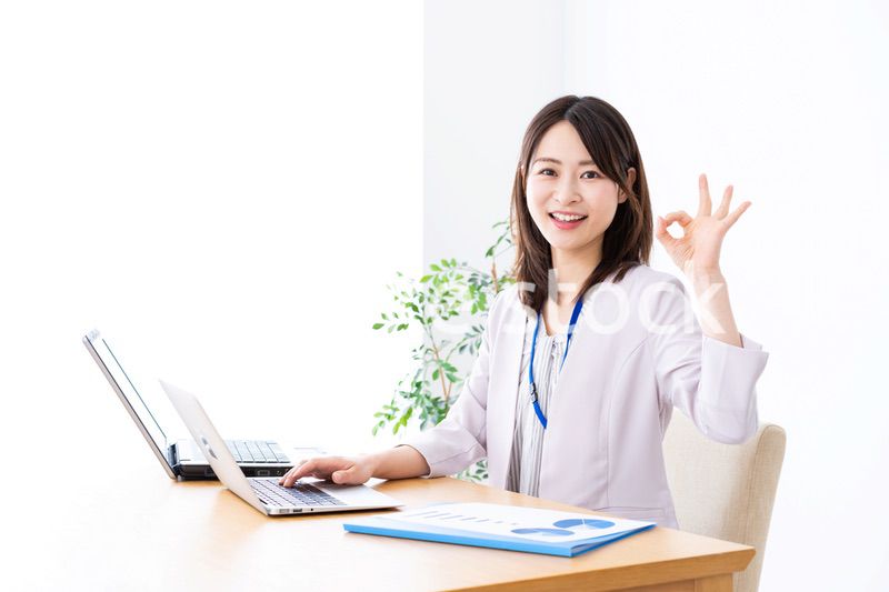 オフィスでグッドサインをする若いビジネスウーマン