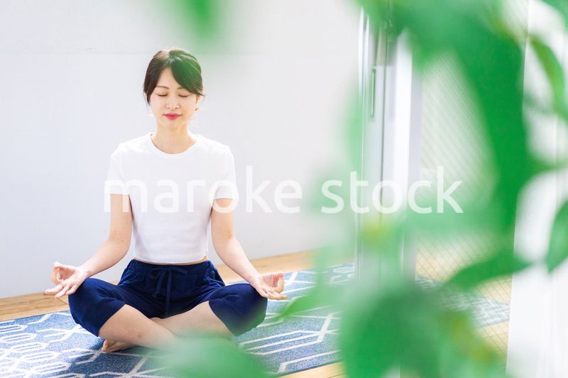 おうちでヨガをする若い女性