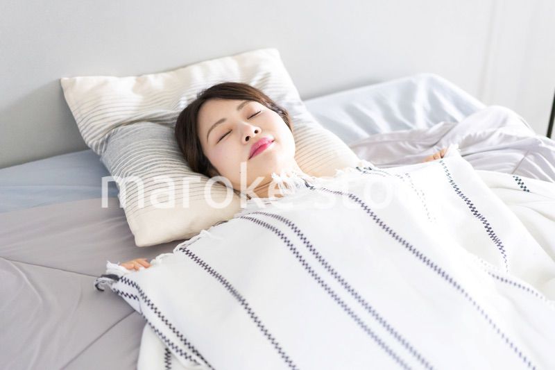 ベッドで熟睡する若い女性