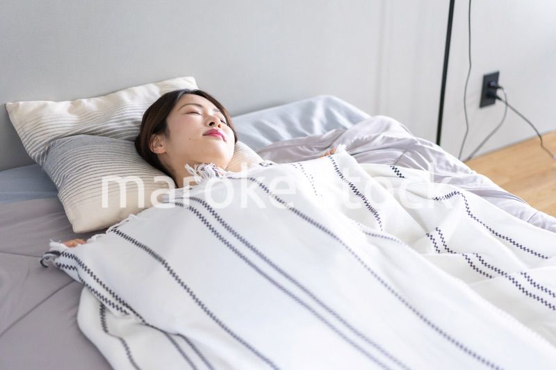 ベッドで熟睡する若い女性