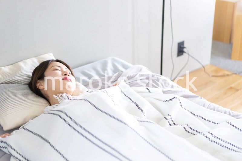 ベッドで熟睡する若い女性