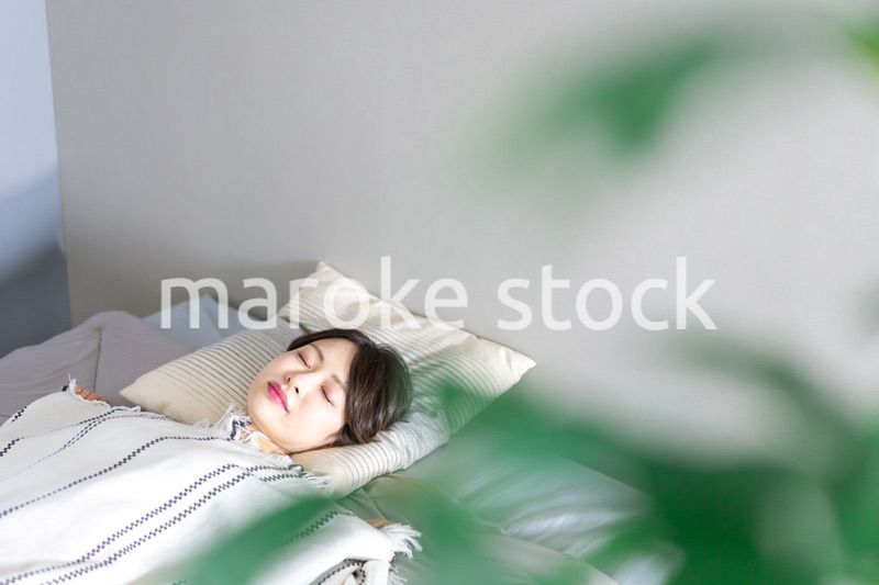 ベッドで熟睡する若い女性