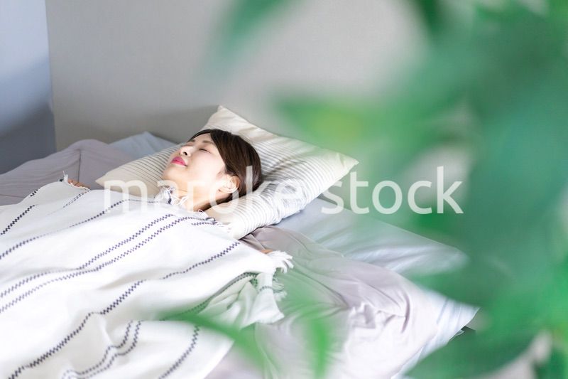 ベッドで熟睡する若い女性