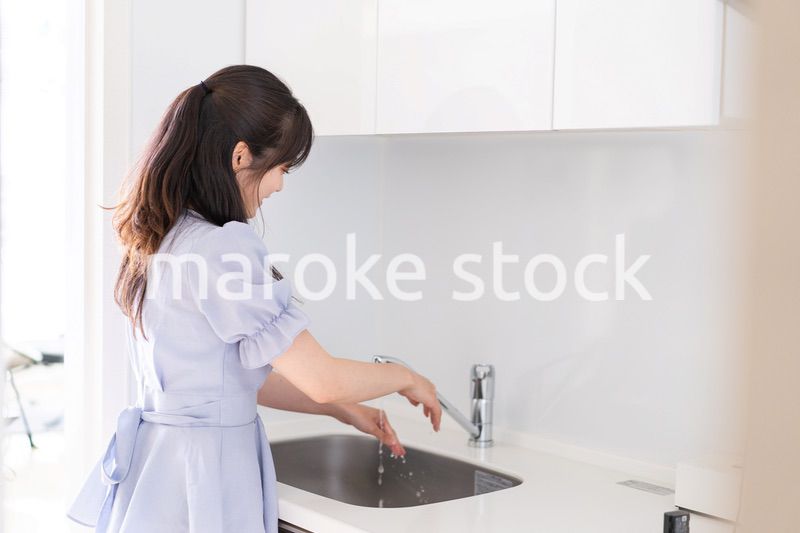 食器洗いをする若い女性