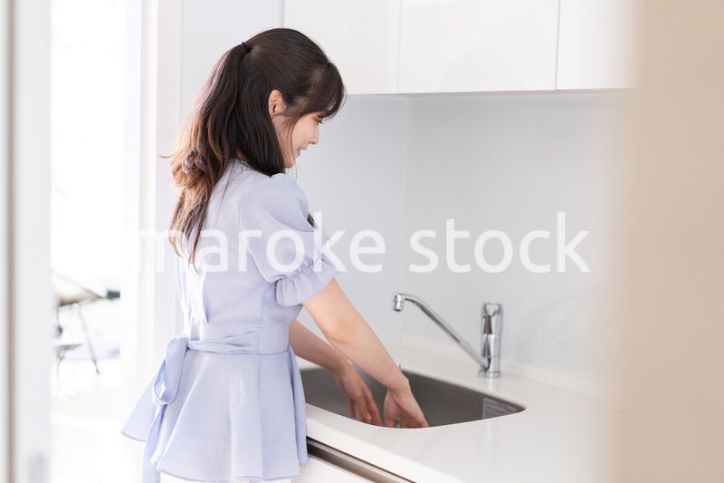 食器洗いをする若い女性