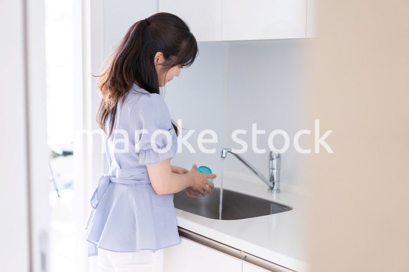 食器洗いをする若い女性
