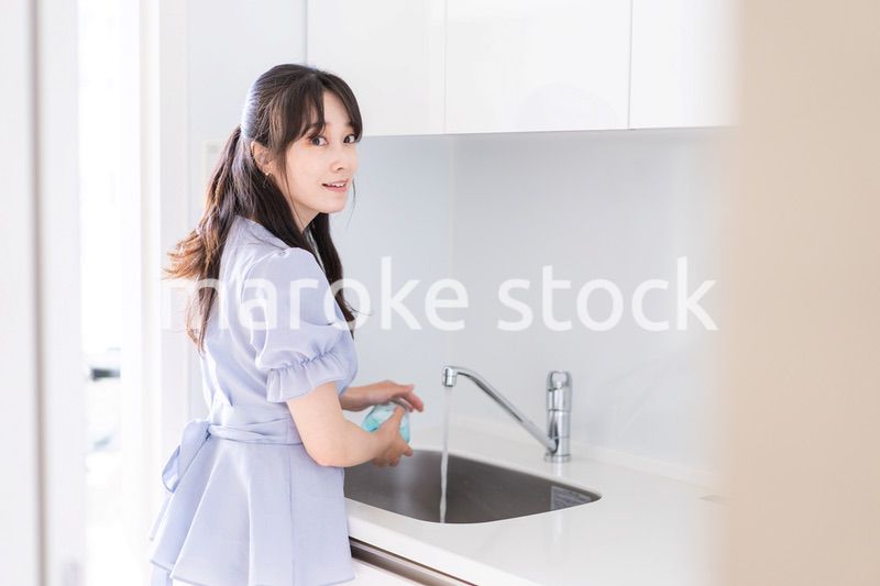 食器洗いをする若い女性