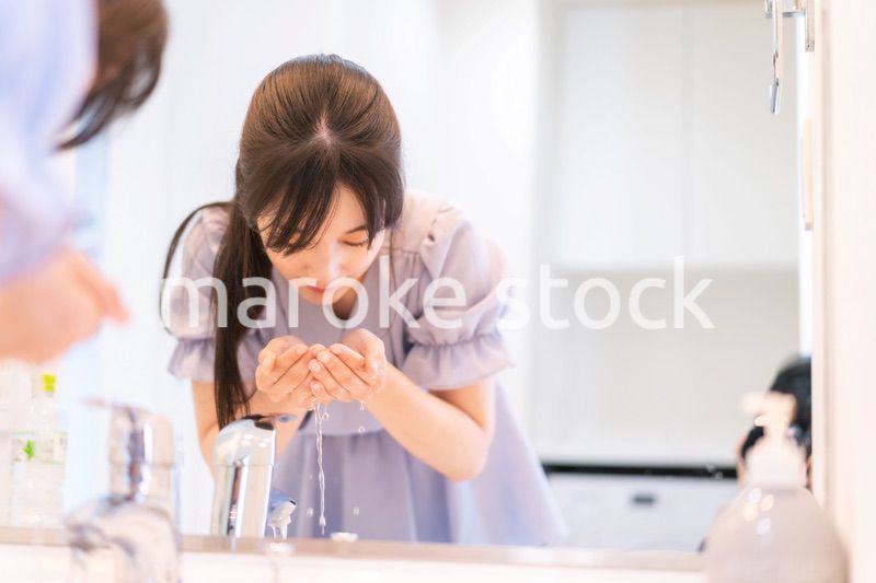 家で洗顔をする若い女性