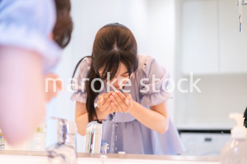 家で洗顔をする若い女性