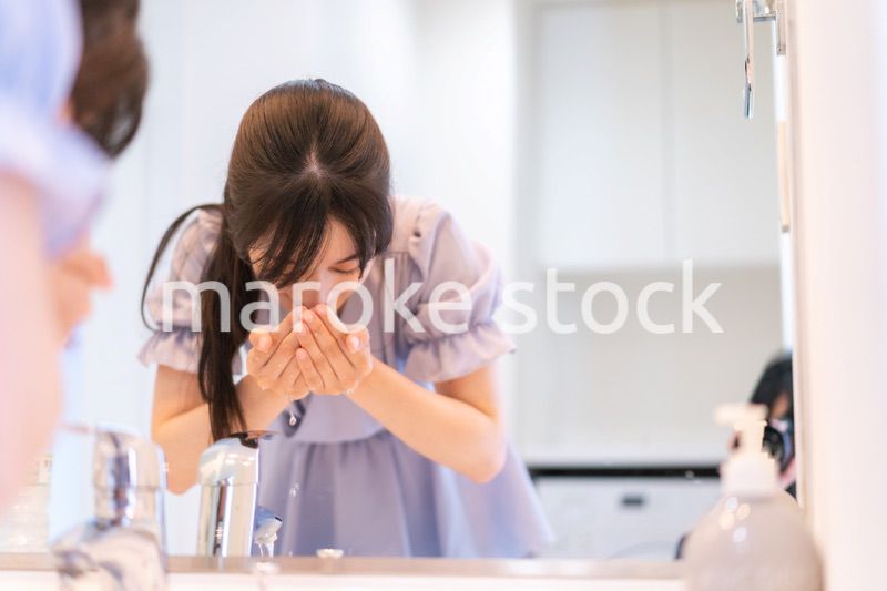 家で洗顔をする若い女性
