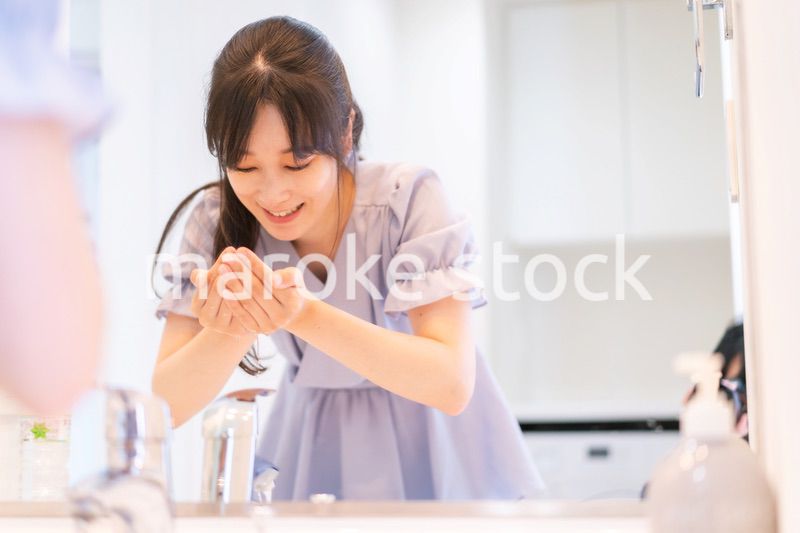 家で洗顔をする若い女性