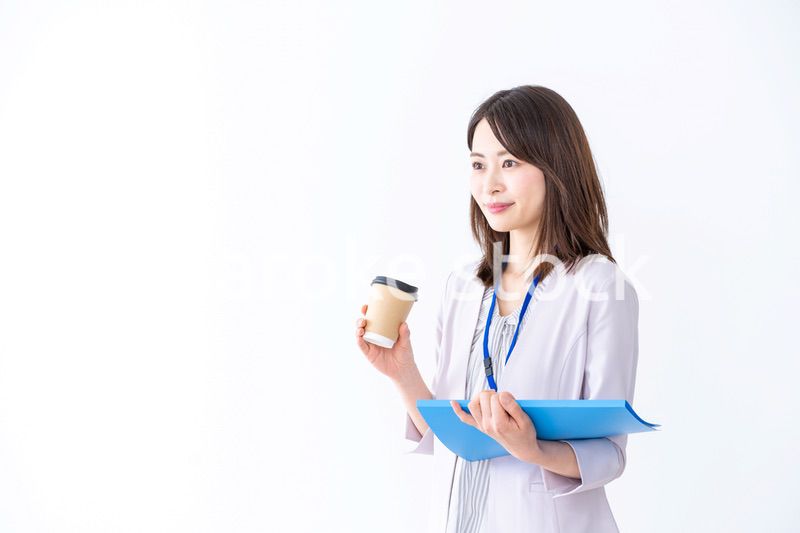 コーヒーを持ってオフィスを歩く美人のビジネスウーマン