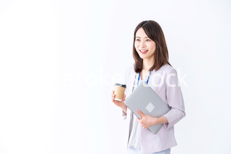 コーヒーを持ってオフィスを歩く美人のビジネスウーマン