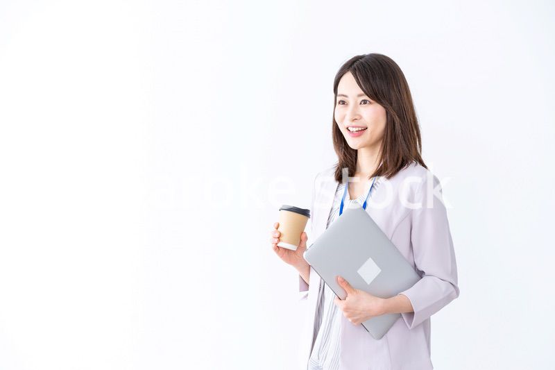 コーヒーを持ってオフィスを歩く美人のビジネスウーマン