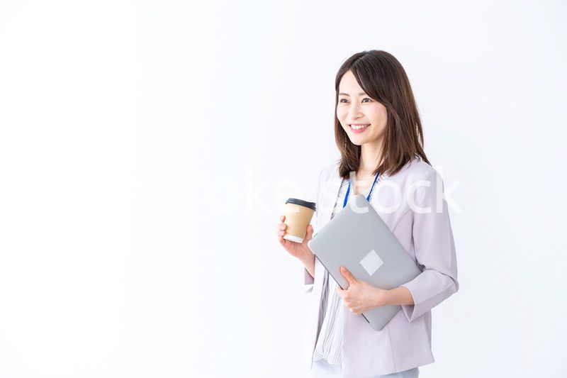 コーヒーを持ってオフィスを歩く美人のビジネスウーマン