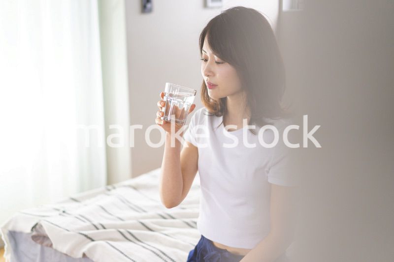 起きて水分補給をする若い女性