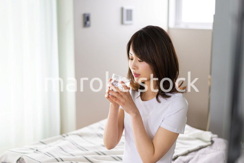起きて水分補給をする若い女性