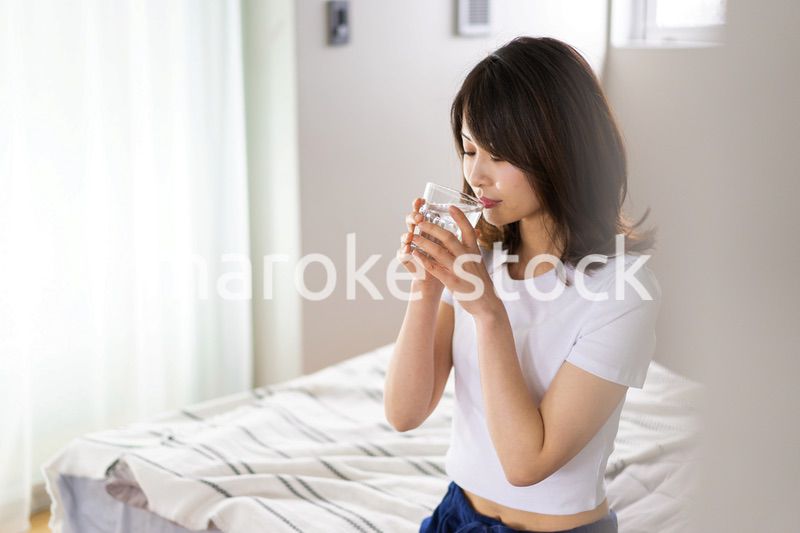 起きて水分補給をする若い女性