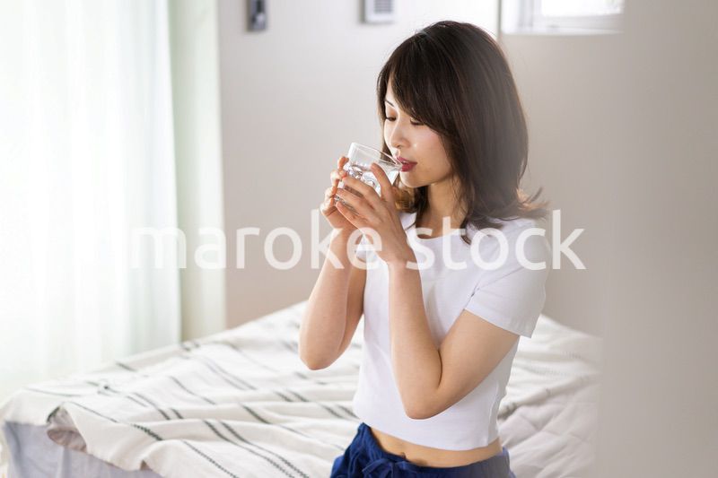 起きて水分補給をする若い女性